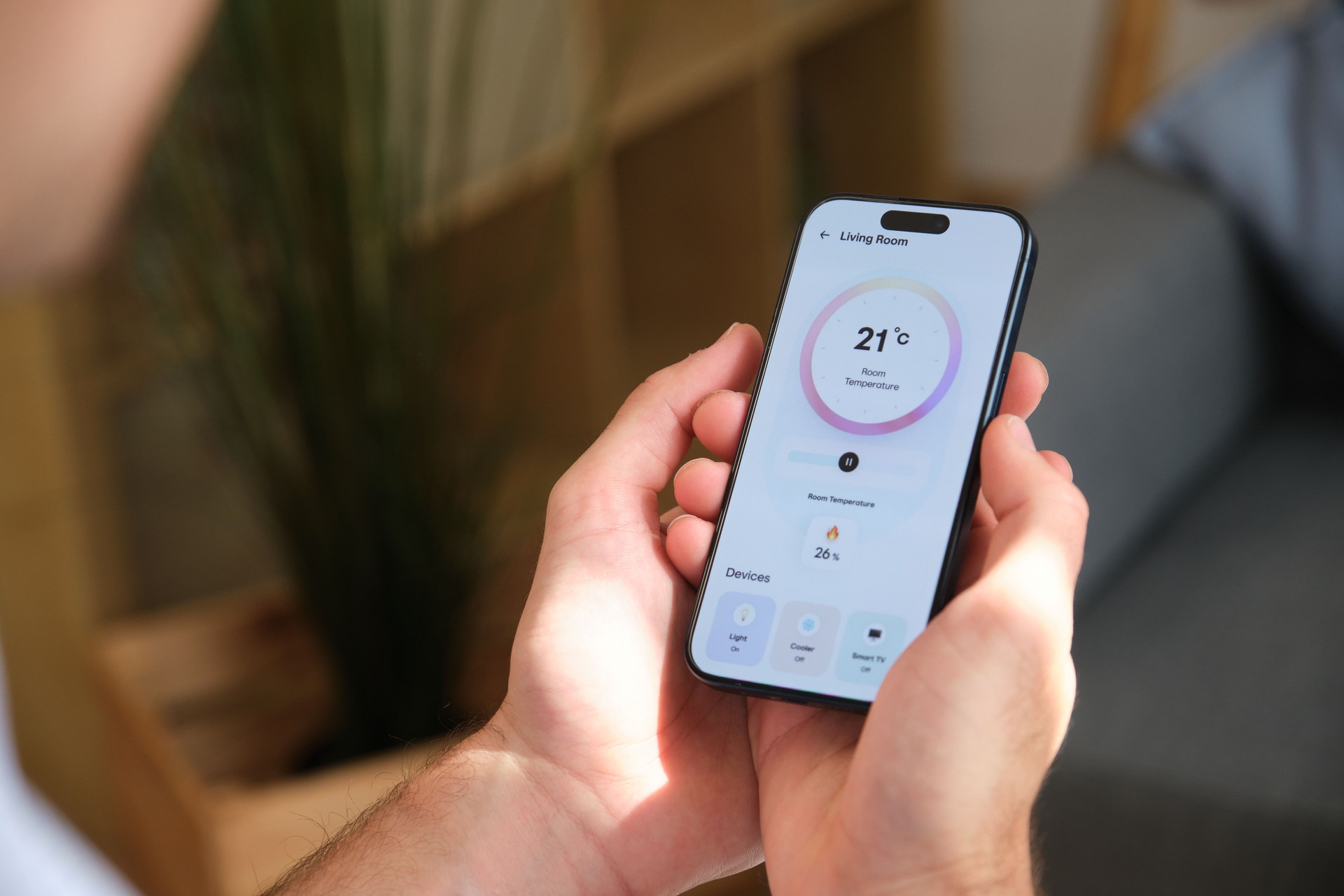 Man controlling home temperature with smartphone app Man controlling home temperature with smartphone app