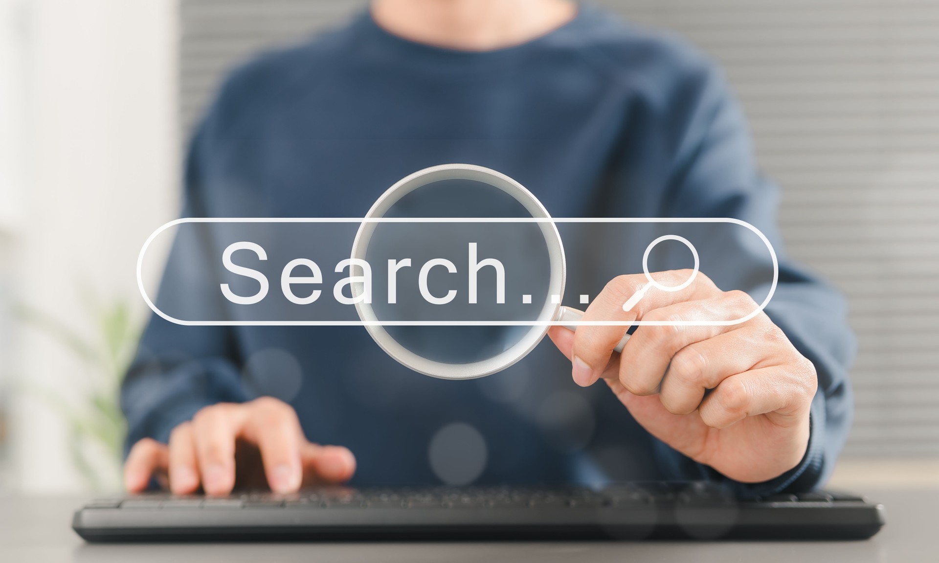 SEO search engine optimization concept. Person uses keyboard while holding magnifying glass with search bar labeled "Search", online search engine optimization, and digital marketing strategies. SEO search engine optimization concept. Person uses keyboard while holding magnifying glass with search bar labeled "Search", online search engine optimization, and digital marketing strategies.